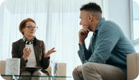 A male therapist sits on the couch talking with his own therapist, a woman