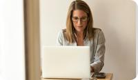 A therapist uses her laptop to vet EHRs that meet the mental health EHR requirements for her practice.