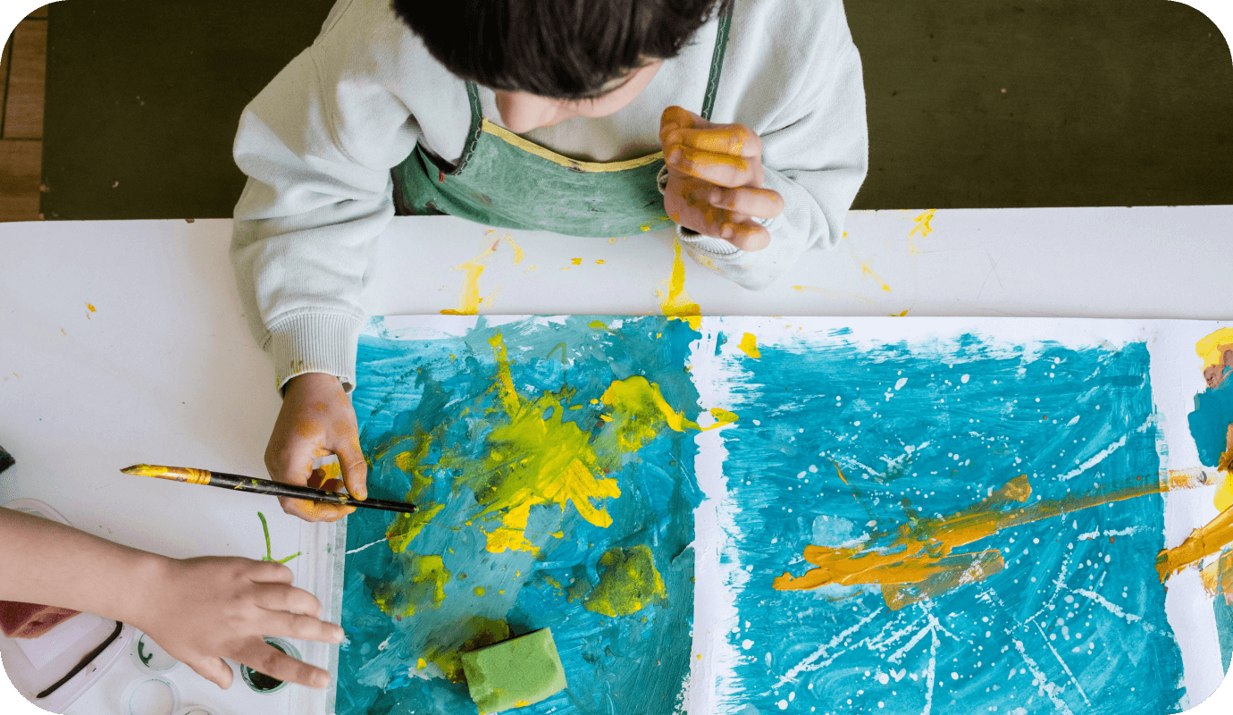 A child paints as he participates in art therapy activities pdf for anxiety and PTSD