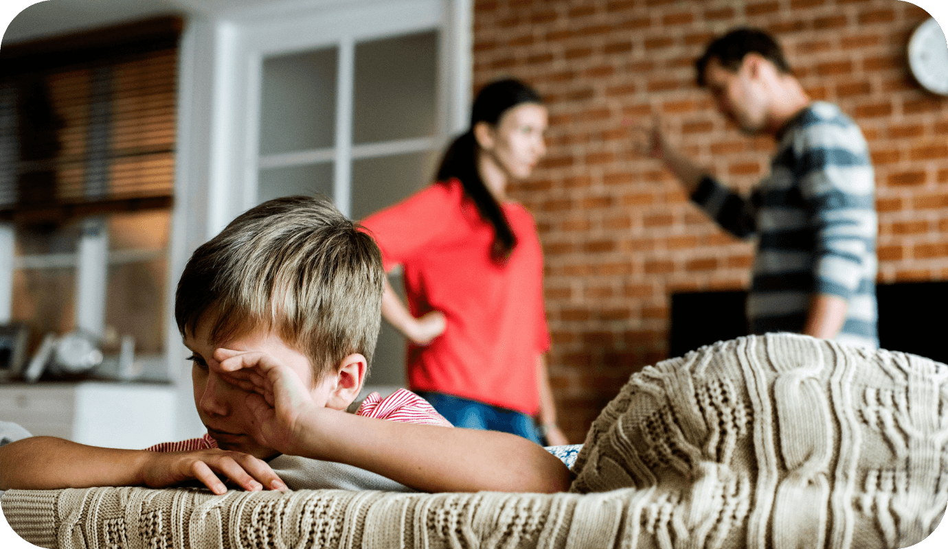 A family, two adults and one child, are in a room, the two adults are engaged in an argument while the child faces away from them on the couch, hand covering his face. Family therapy interventions can strengthen a variety of relationships. This article shares family therapy techniques you can use with clients.