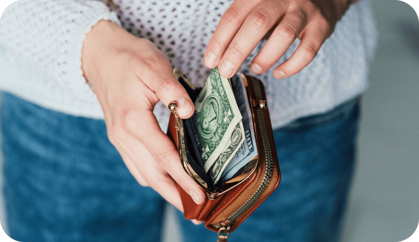 A therapy client takes out there wallet to pay in cash as part of a pay what you can model of paying their therapist